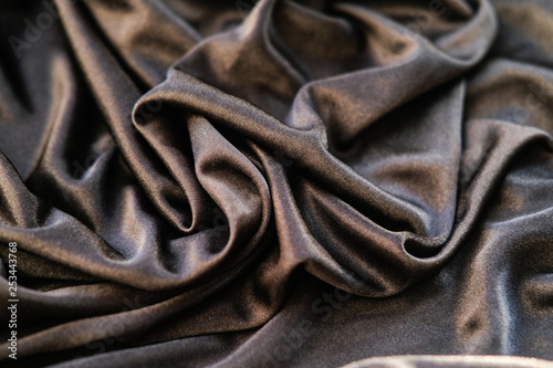 Fabric gold waves - material for background and texture. Close up black fabric.