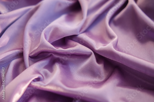 Close up pink fabric. The purple fabric is laid out waves. Fuchsia sateen fabric for background or texture.