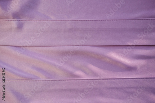 Close up pink fabric. The purple fabric is laid out waves. Fuchsia sateen fabric for background or texture.