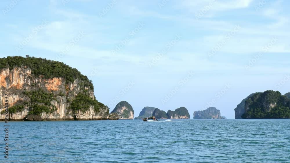 Cliff islands of Phang Nga bay in Thailand sea. Traditional thai boat travels fast Cliff islands of Phang Nga bay in Thailand sea. Traditional thai boat travels fast