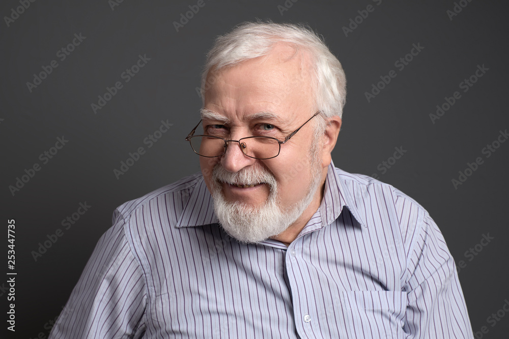 business, gray-haired man on a gray background seriously looking business, gray-haired man on a gray background seriously looking