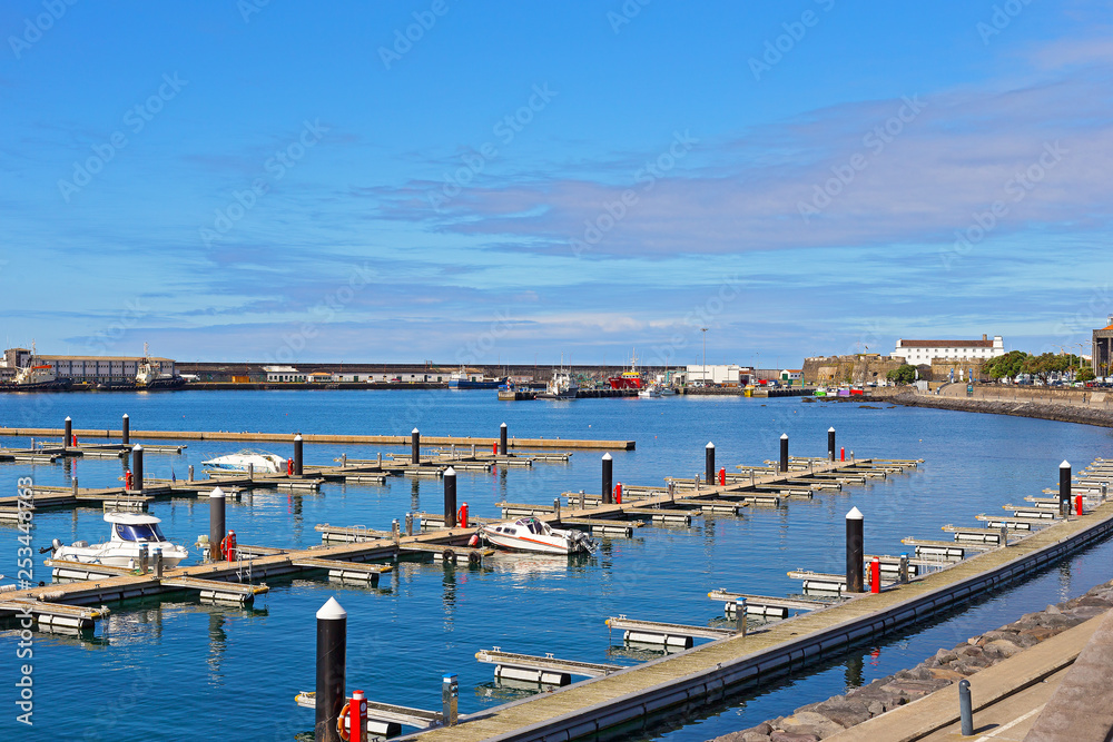 Ocean port and motorboat piers of Ponta Delgada, Azores, Portugal. Moored vessels and motorboats at port piers on a beautiful sunny morning.