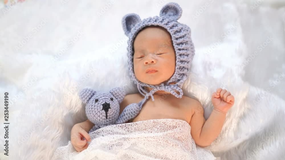 newborn baby in bear hat sleeping on a fur bed newborn baby in bear hat sleeping on a fur bed
