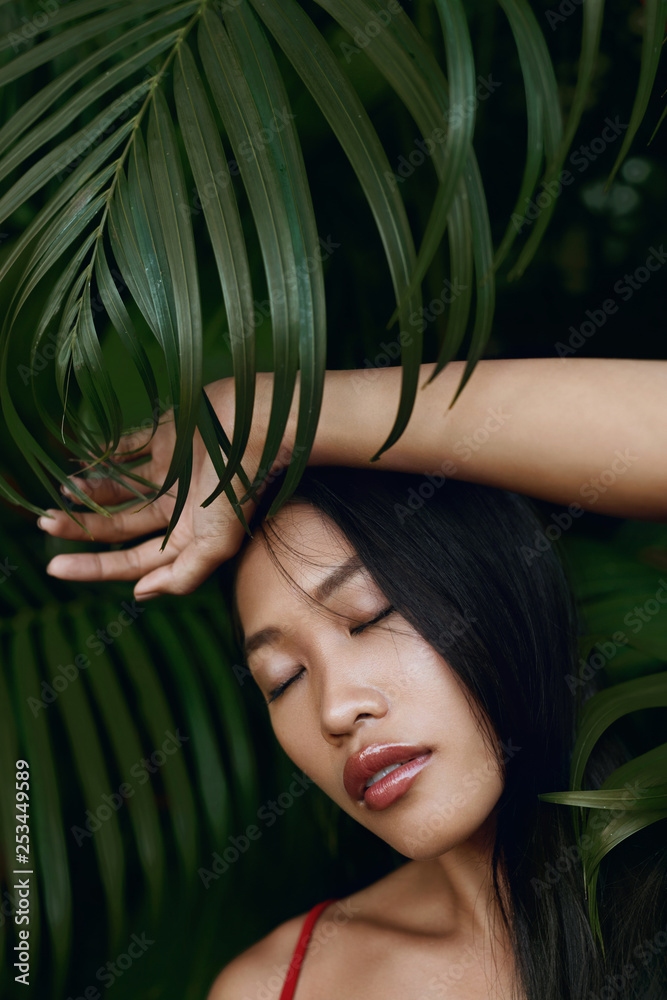 Beauty. Asian woman with beautiful face and natural palm leaves Beauty. Asian woman with beautiful face and natural palm leaves