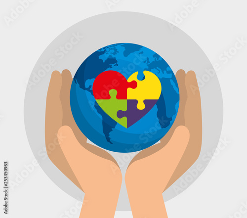 hand with global map and heart puzzle to autism day