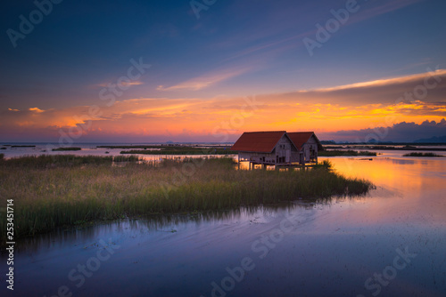 Old twin wooden houses at Thale Noi with nice sky sunset, Phatthalung province in Thailand.
