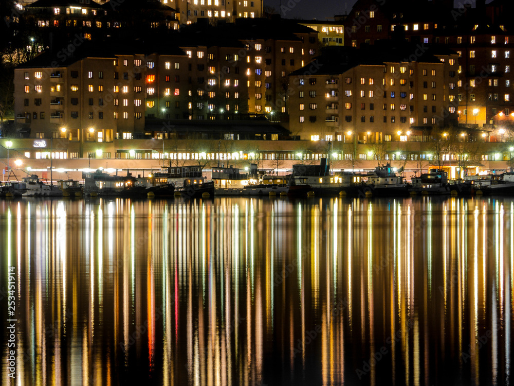 STOCKHOLM SWEDEN View from City Hall at night with reflection of Södermalm in water. Riddarfjärden is part of fresh water lake Mälaren.