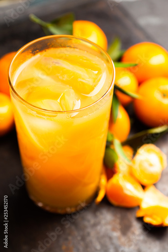 Fresh beverage with mandarines on the rustic background. Selective focus. Shallow depth of field.