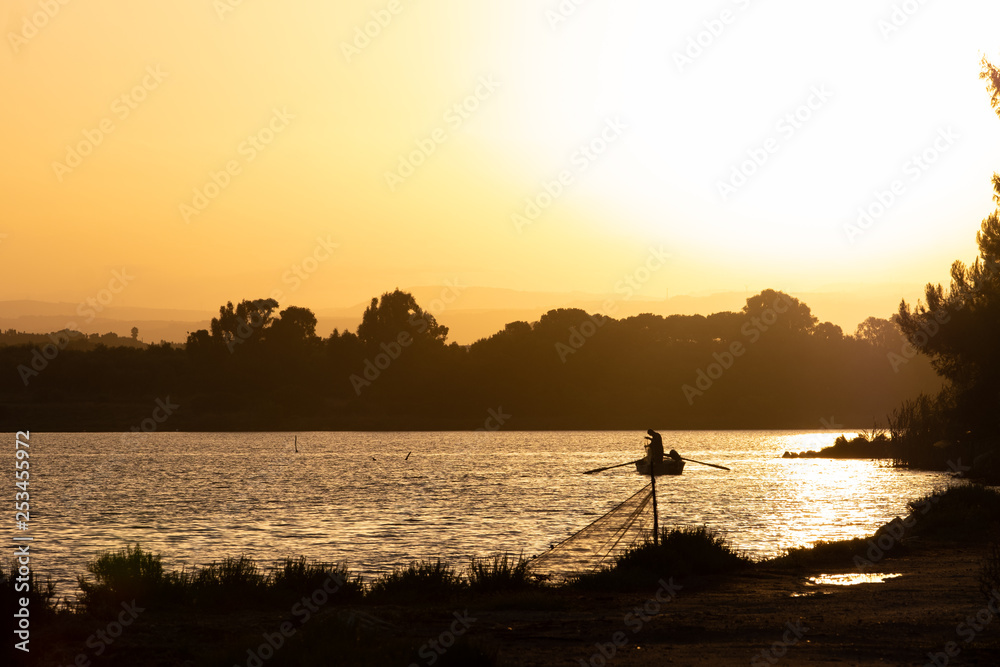 Fischer früh morgens beim Fischen in einer Lagune bei Alghero auf Sardinien, Italien