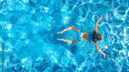 Active girl in swimming pool aerial drone view from above  young woman swims in blue water  tropical vacation  holiday on resort concept