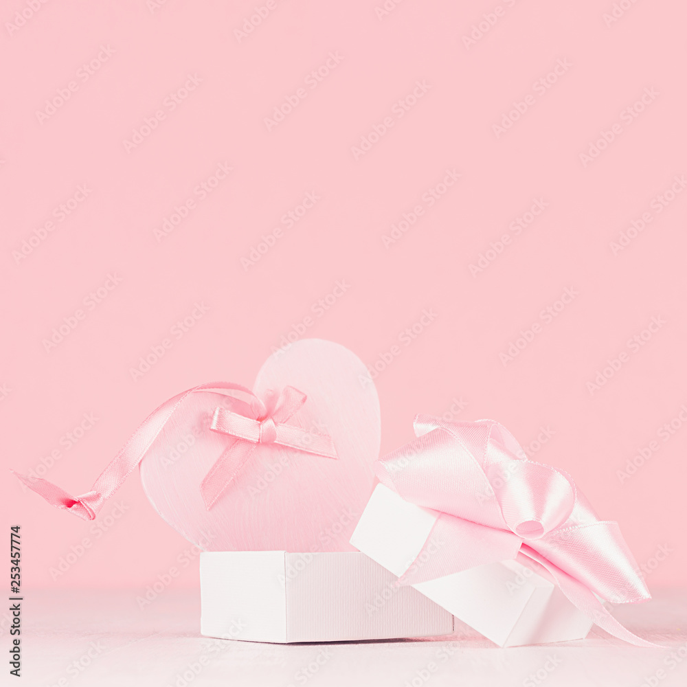 Romance celebration background for Valentine and wedding - cute heart with silk ribbon and gift on white wood board, closeup.