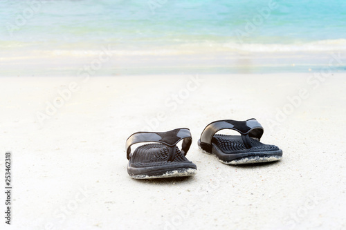 Sandals on the sandy beach summer concept