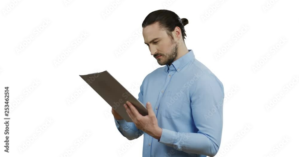 Portrait shot of the attractive Caucasian man in the blue shirt standing with a folder with documents in hands and then looking to the camera with a smile. White background.