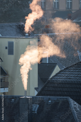 Smoke from chimneys on rooftops