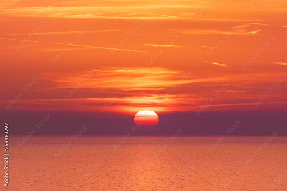 Stunning red sunset over the sea horizon.