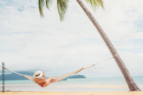 Asian women relaxing in hammock summer holiday on beach