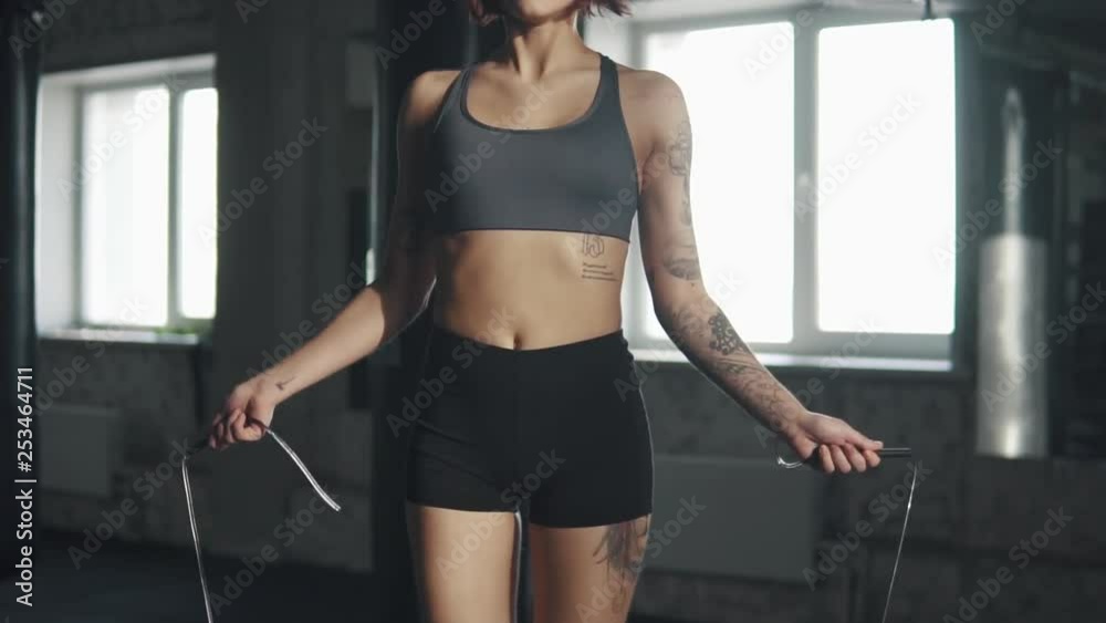 portrait of a female athlete in the gym. young girl doing cardio jumping rope portrait of a female athlete in the gym. young girl doing cardio jumping rope