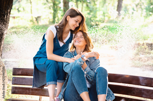 Two beautiful young woman resting on a bench