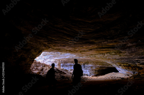Two unrecognizable tourists at the entrance of Gruta Da Lapa Doce, cave in Iraquara, Chapada Diamantina, Bahia, Brazil