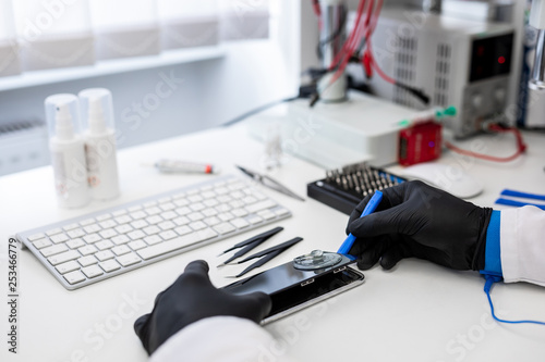 Фотография Repair and service of broken smart phone in professional office