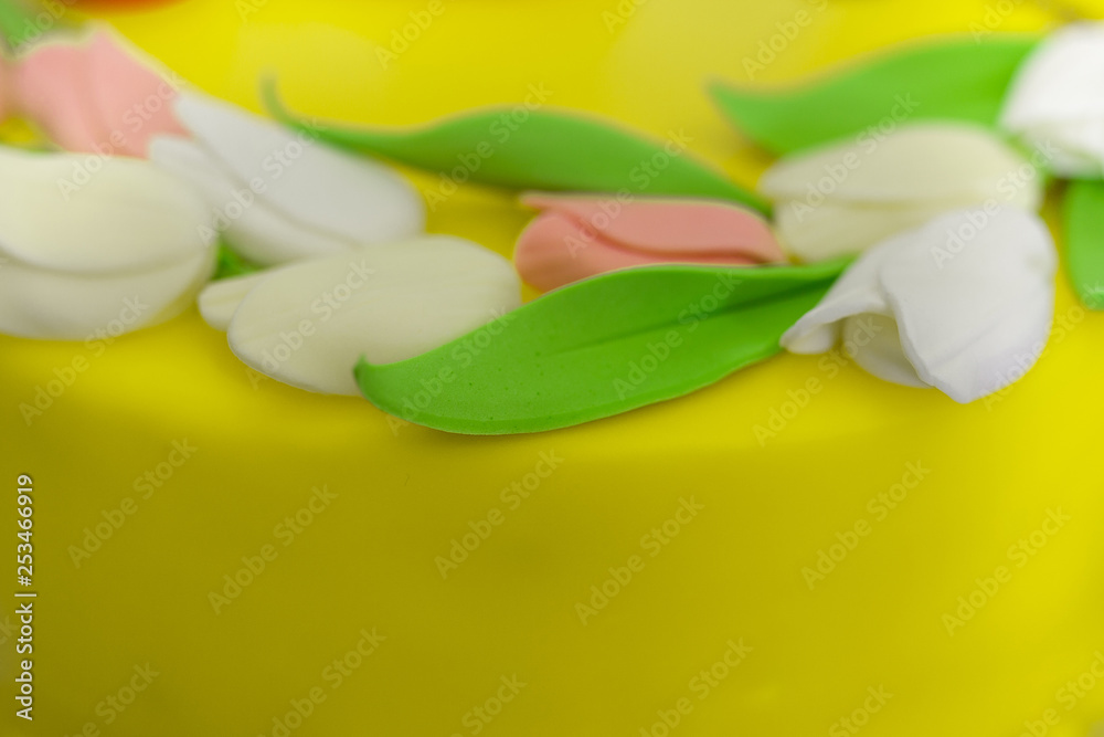 Top decoration of cake with tulip flower made from mastic on yellow background, spring mood Top decoration of cake with tulip flower made from mastic on yellow background, spring mood