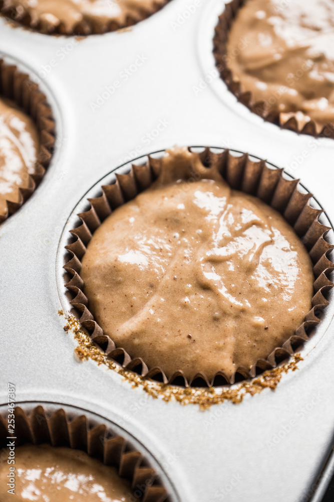 Muffins making. Raw chocolate dough in form ready to bake. Selective focus. Muffins making. Raw chocolate dough in form ready to bake. Selective focus.