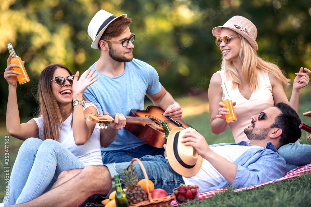 Happy young friends having picnic in the park Happy young friends having picnic in the park