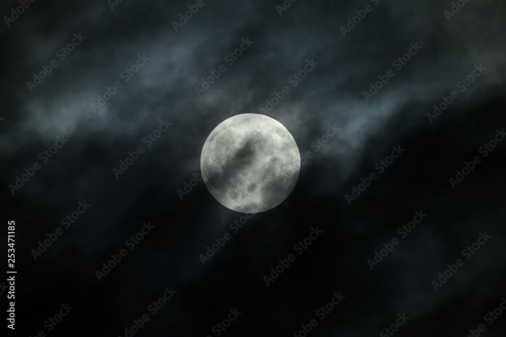 Full Moon and clouds on the night sky 