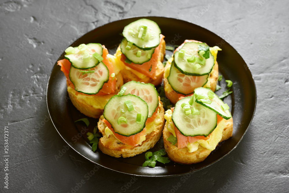 Sandwiches with salmon, scrambled eggs and cucumber Sandwiches with salmon, scrambled eggs and cucumber