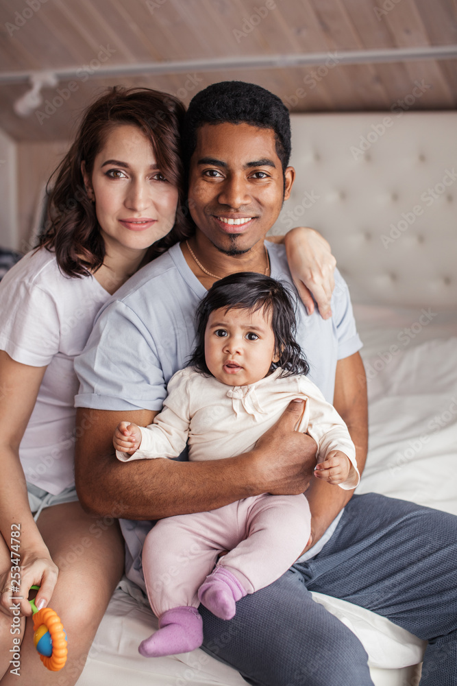 happy diverse family looking at the camera indoors, close up photo