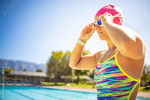 Close up image of a beautiful female swimmer in a swimming pool getting ready to train.