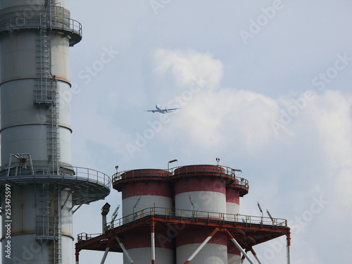 Turbigo, MIlan, 23/03/2009. Plane flies over the chimneys of a power plant
