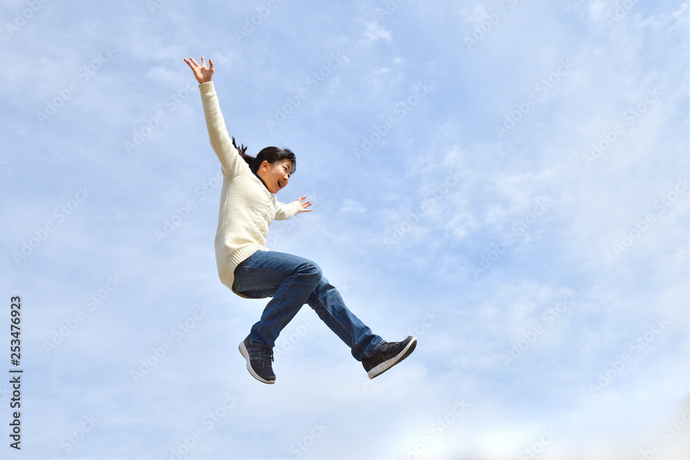 Japanese girl jumping in the blue sky Japanese girl jumping in the blue sky