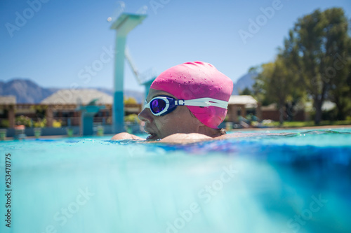 Close up image of a beautiful female swimmer in a swimming pool getting ready to train.