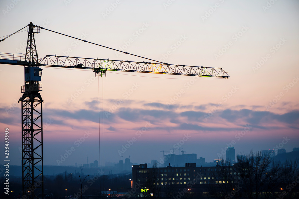 high-rise building crane on the background of the evening sky, building