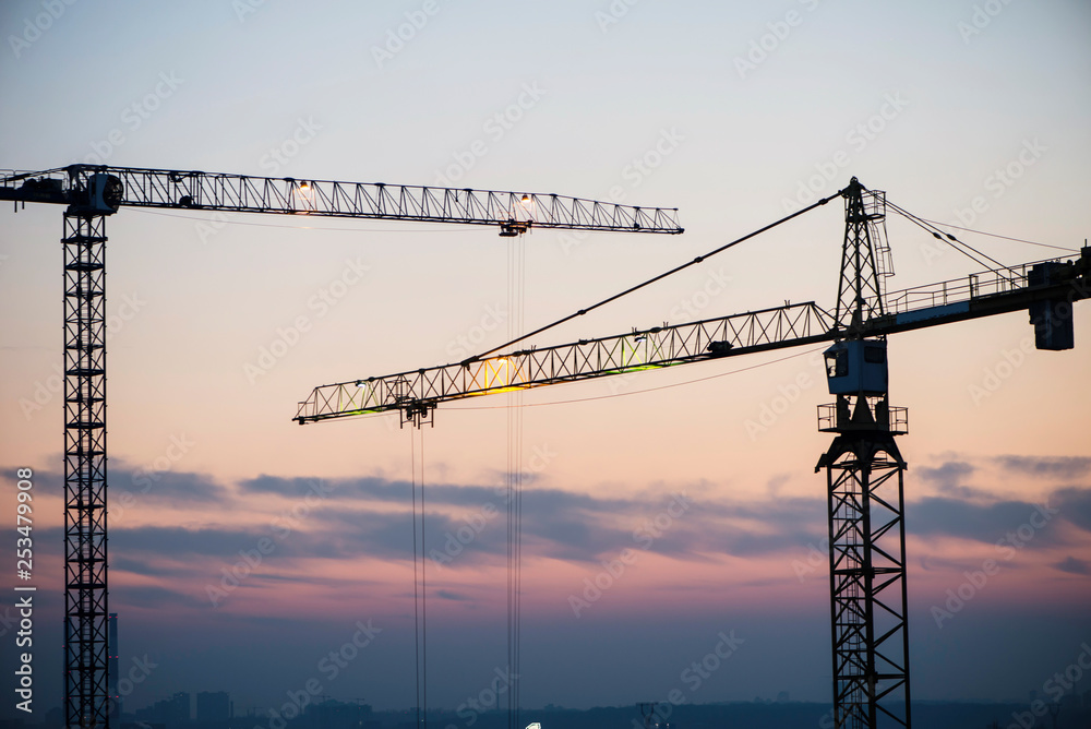 high-rise building crane on the background of the evening sky, building