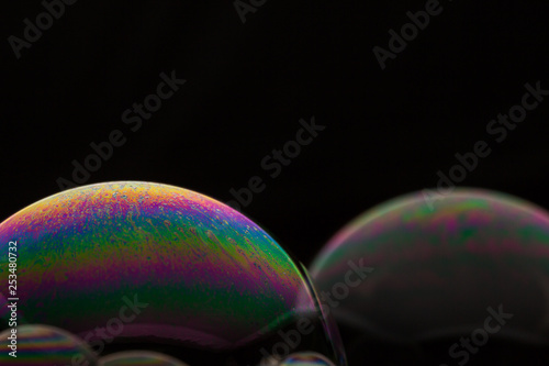 A bubble in rainbow colors on a black background.