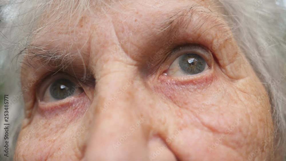 Portrait of old grandmother looking up. Close up eyes of an elderly woman with wrinkles around them Portrait of old grandmother looking up. Close up eyes of an elderly woman with wrinkles around them