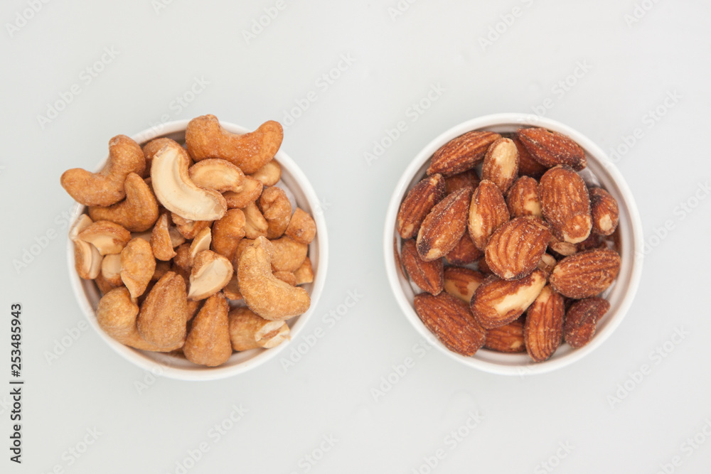 salted Cashews and almonds snack put on white background, Isolate dry and salted cashews and almonds in small white cup salted Cashews and almonds snack put on white background, Isolate dry and salted cashews and almonds in small white cup