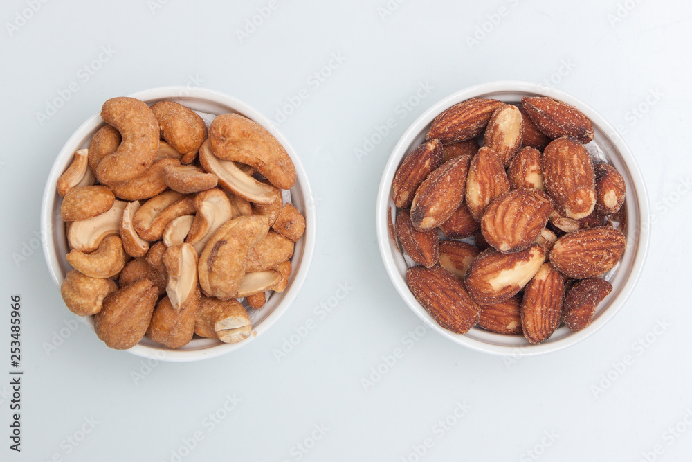 salted Cashews and almonds snack put on white background, Isolate dry and salted cashews and almonds in small white cup salted Cashews and almonds snack put on white background, Isolate dry and salted cashews and almonds in small white cup