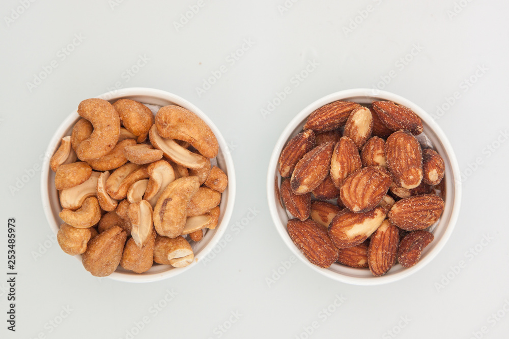 salted Cashews and almonds snack put on white background, Isolate dry and salted cashews and almonds in small white cup salted Cashews and almonds snack put on white background, Isolate dry and salted cashews and almonds in small white cup