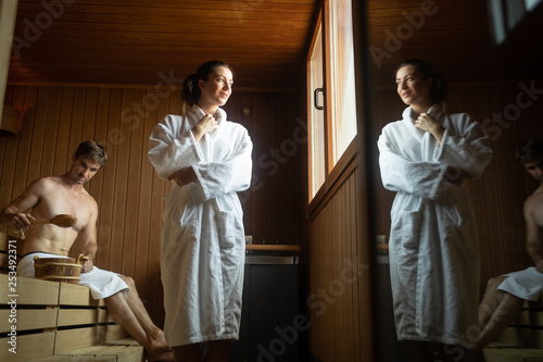 Young happy couple relaxing inside a sauna at spa resort hotel luxury