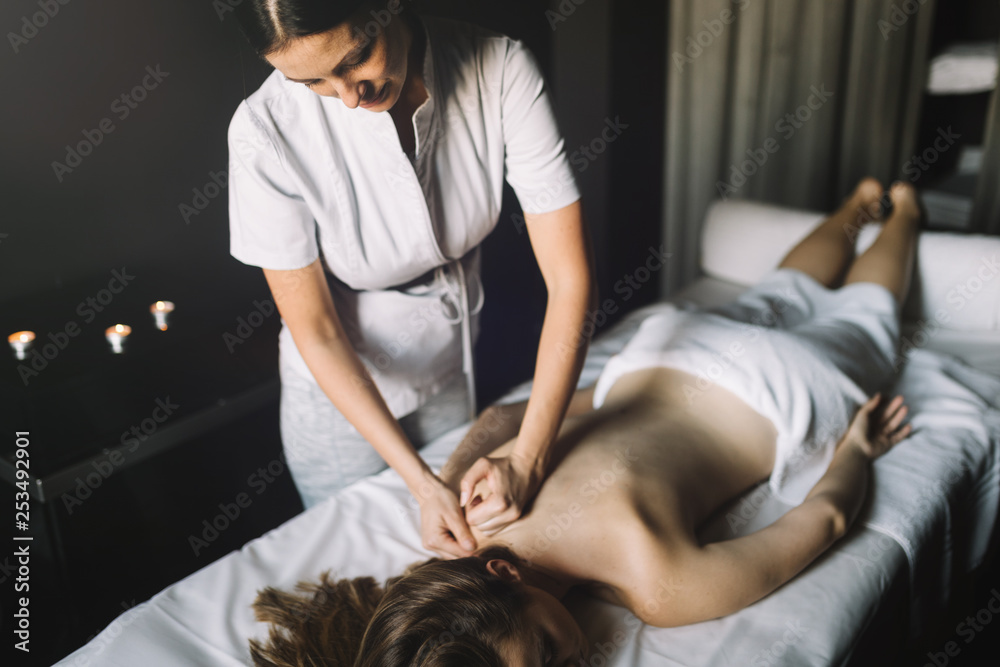 Young woman receiving a back massage in a spa center Young woman receiving a back massage in a spa center