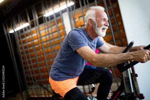 Mature fit couple exercising in gym to stay healthy