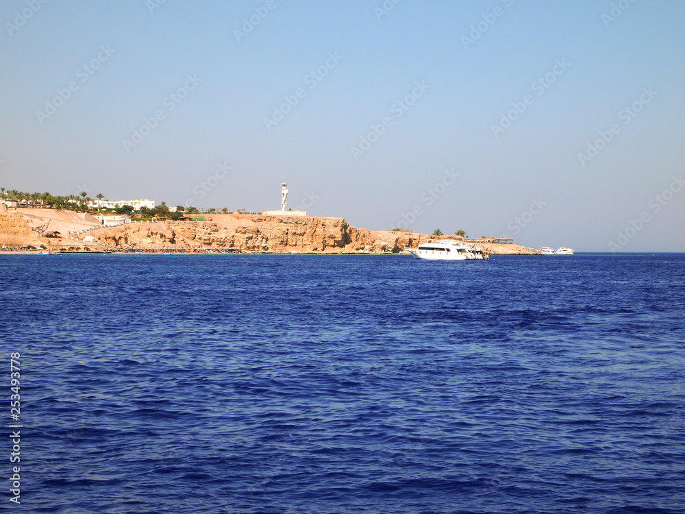 The rocky coast of the red sea, Sharm El Sheikh. Blue sea and rocky shore.