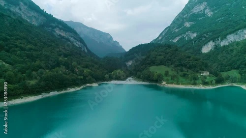 Lago di Tenno blue lake in valley Italy.
Panshot from low to a higher point of view photo