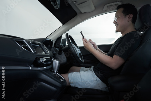 Asian man driver using smart phone in car . © jamesteohart