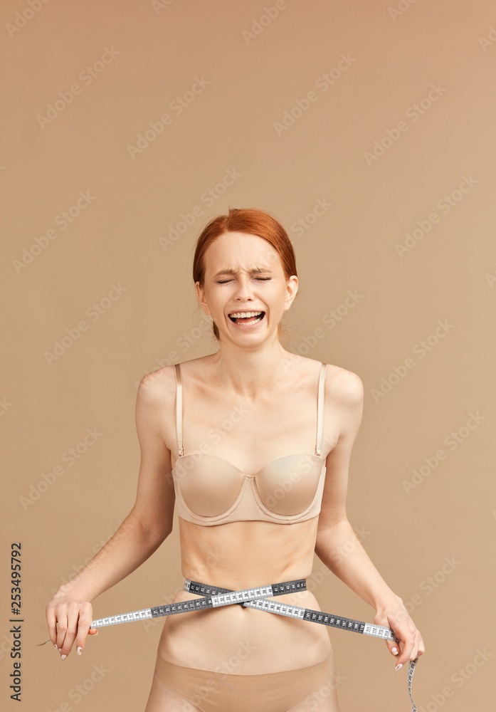 Skinny suffering female in nude underwear screaming, being tied