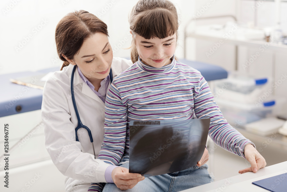 Friendly doctor showing an x-ray to a young patient Friendly doctor showing an x-ray to a young patient