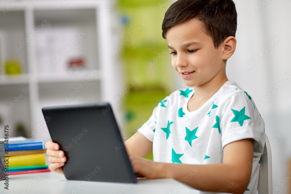 education, people and learning concept - happy student boy with tablet pc computer and notebook learning at home education, people and learning concept - happy student boy with tablet pc computer and notebook learning at home